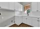 Bright laundry room features white cabinetry, countertop space, and a window providing natural light at 2805 Proust Ct, Henderson, NV 89044