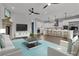 Open concept living room and kitchen with hardwood floors, ceiling fans, bar stool seating, and a fireplace at 2805 Proust Ct, Henderson, NV 89044