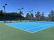 Community tennis court featuring a bright blue court, green base, lighting, and ample space for sports enthusiasts at 2805 Proust Ct, Henderson, NV 89044