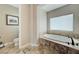 Bathroom featuring soaking tub with decorative tile surround, and decorative tile flooring at 2824 Sisteron Ct, Henderson, NV 89044