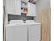 Functional laundry room equipped with a washer, dryer, and overhead cabinets for organized storage at 301 Resolute Ave, Henderson, NV 89011