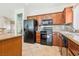 Well-equipped kitchen with black appliances, tile backsplash, and wooden cabinetry at 3029 Paseo Hills Way, Henderson, NV 89052