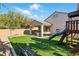 Backyard featuring a covered patio, outdoor seating, turf, playground, BBQ and desert landscaping at 3756 Toscanella Ave, Henderson, NV 89052