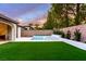 Expansive backyard featuring lush artificial turf and a sparkling pool and spa at 42 Carolina Cherry Dr, Las Vegas, NV 89141