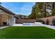 Expansive backyard featuring lush artificial turf and a sparkling pool and spa at 42 Carolina Cherry Dr, Las Vegas, NV 89141