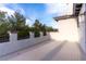 Open-air balcony with stucco walls, iron railing, and views of the tree line at 42 Carolina Cherry Dr, Las Vegas, NV 89141