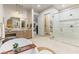 Bright bathroom features a soaking tub, wood vanity, marble countertops, and glass enclosed shower at 42 Carolina Cherry Dr, Las Vegas, NV 89141