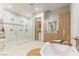 Well-lit bathroom highlighting a luxurious walk-in shower, soaking tub, and natural wood cabinetry at 42 Carolina Cherry Dr, Las Vegas, NV 89141