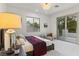 Bright bedroom featuring neutral colors, decorative lamp and balcony access at 42 Carolina Cherry Dr, Las Vegas, NV 89141