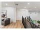 Bright hallway features hardwood floors, a stylish armchair and an elegant staircase with decorative black railings at 42 Carolina Cherry Dr, Las Vegas, NV 89141