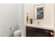 Stylish powder room features a decorative mirror, modern vanity and a toilet at 42 Carolina Cherry Dr, Las Vegas, NV 89141