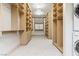 Extensive walk-in closet with custom wood shelving, drawers, and washer/dryer at 42 Carolina Cherry Dr, Las Vegas, NV 89141
