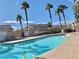 Sparkling community pool with clear blue water, palm trees, and comfortable lounge seating at 4675 Color Up Ct # 101, Las Vegas, NV 89122