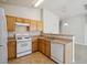 Classic kitchen with wood cabinets, tile flooring, and white appliances at 4675 Color Up Ct # 101, Las Vegas, NV 89122