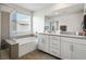 Stylish bathroom with a double vanity, shower, and large bathtub beneath a bright window at 4698 Lucky Jade Ave, Las Vegas, NV 89141