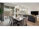 Dining room with modern lighting, large windows, backyard access, and view of living room at 4698 Lucky Jade Ave, Las Vegas, NV 89141