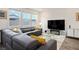 Comfortable living room with a plush sectional sofa, large windows, and modern entertainment center at 4698 Lucky Jade Ave, Las Vegas, NV 89141