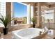 Bright bathroom with a soaking tub under a large window, offering views of the mountains at 5020 Spanish Heights Dr, Las Vegas, NV 89148