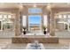 A luxurious spa-like bathroom with a soaking tub, dual vanities, and scenic mountain views at 5020 Spanish Heights Dr, Las Vegas, NV 89148