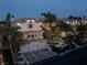 Elegant multi-story home featuring a red tile roof, a three-car garage, and lush tropical landscaping at 5020 Spanish Heights Dr, Las Vegas, NV 89148