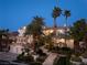 Elegant multi-story home with lush landscaping, a 3-car garage, and palm trees at twilight at 5020 Spanish Heights Dr, Las Vegas, NV 89148