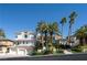 Elegant multi-story home with lush landscaping, a 3-car garage, and palm trees at 5020 Spanish Heights Dr, Las Vegas, NV 89148