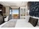 Bright main bedroom with balcony access, shuttered windows, and a decorative padded headboard at 5020 Spanish Heights Dr, Las Vegas, NV 89148