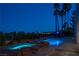 Backyard pool area at dusk features a spa, rock waterfall, and lush landscaping at 5020 Spanish Heights Dr, Las Vegas, NV 89148