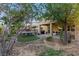 Lush backyard featuring a trampoline, a grill, mature trees, and a covered patio, perfect for outdoor activities and relaxation at 5144 Poem Ct, North Las Vegas, NV 89081