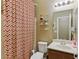 Well-lit bathroom with a shower, patterned shower curtain, vanity, and storage shelves at 5144 Poem Ct, North Las Vegas, NV 89081