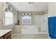 Bright bathroom featuring a soaking tub, separate shower, and elegant window treatment at 5144 Poem Ct, North Las Vegas, NV 89081