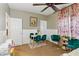 Inviting bedroom with daybed, ceiling fan, green chairs, and floral curtains at 5144 Poem Ct, North Las Vegas, NV 89081