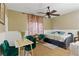 Cozy bedroom with daybed, ceiling fan, green chairs, and floral curtains at 5144 Poem Ct, North Las Vegas, NV 89081