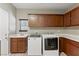 Functional laundry room with washer, dryer, sink, storage cabinets, and tiled floors at 5144 Poem Ct, North Las Vegas, NV 89081