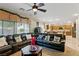 Comfortable living room featuring a plush leather sofa, ceiling fan, and natural light at 5144 Poem Ct, North Las Vegas, NV 89081