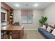 Cozy home office featuring a large desk, built-in shelves, a comfortable couch, and natural light from the window at 5144 Poem Ct, North Las Vegas, NV 89081