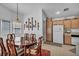 A dining room with an oval table, wood chairs, hanging lamp, and decorations at 520 Stonehurst Dr, North Las Vegas, NV 89031