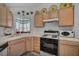 Kitchen featuring white appliances, light wood cabinets, and neutral countertops at 520 Stonehurst Dr, North Las Vegas, NV 89031