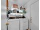 Compact laundry room featuring a washer and dryer, storage shelves, and tile floors at 520 Stonehurst Dr, North Las Vegas, NV 89031