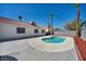 Outdoor in-ground kidney bean shaped pool surrounded by concrete and palm trees in backyard at 520 Stonehurst Dr, North Las Vegas, NV 89031