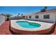 Backyard in-ground pool with surrounding brick and concrete against white house at 520 Stonehurst Dr, North Las Vegas, NV 89031