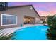 Swimming pool and manicured backyard with large windows and patio seating create the perfect outdoor living space at 5940 Vizzi Ct, Las Vegas, NV 89131