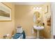 Cozy powder room with pedestal sink, oval mirror, and decorative accents at 5940 Vizzi Ct, Las Vegas, NV 89131