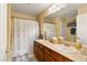 Bathroom featuring double sinks, wooden vanity, and a shower/tub combo with neutral decor at 5940 Vizzi Ct, Las Vegas, NV 89131