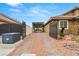 Long gated driveway and carport leading to a house with desert landscaping at 5940 Vizzi Ct, Las Vegas, NV 89131
