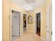 Bright hallway with multiple doorways leading to bedrooms or bathrooms, and neutral tile flooring at 5940 Vizzi Ct, Las Vegas, NV 89131