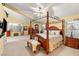 Spacious main bedroom featuring four-poster bed, sitting area, and ample natural light at 5940 Vizzi Ct, Las Vegas, NV 89131
