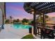 Inviting outdoor space with pergola covered bar area overlooking the pool and lush landscaping at 5940 Vizzi Ct, Las Vegas, NV 89131