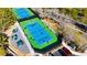 Aerial view of well-maintained tennis courts with lush landscaping and seating areas at 800 Jody Brook Ct, Las Vegas, NV 89145