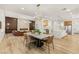 Open-concept dining room features modern chandelier, table with seating, and wood-look tile floors at 800 Jody Brook Ct, Las Vegas, NV 89145